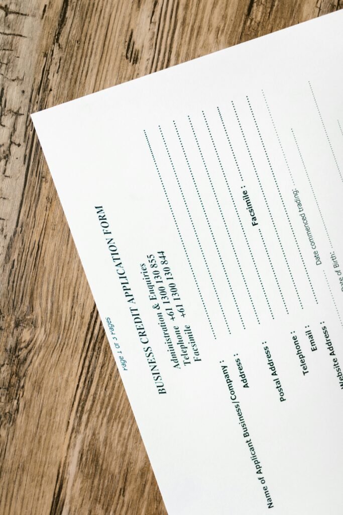 A business credit application form resting on a rustic wooden table, ready for completion.